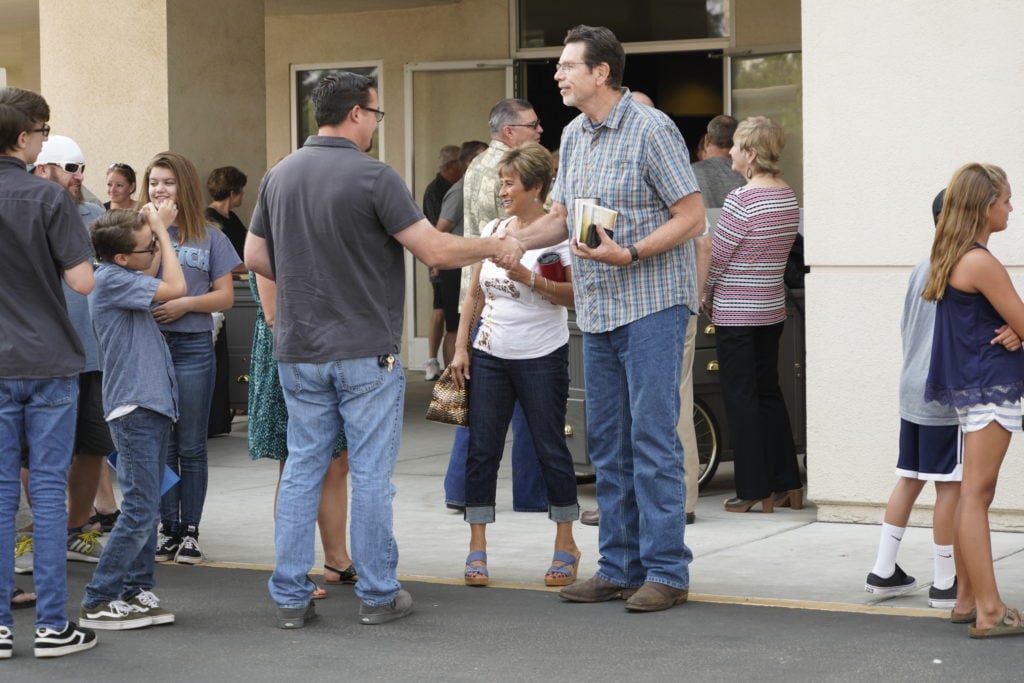 People gathering after a church service, sharing conversations, fellowship, and meaningful community connections