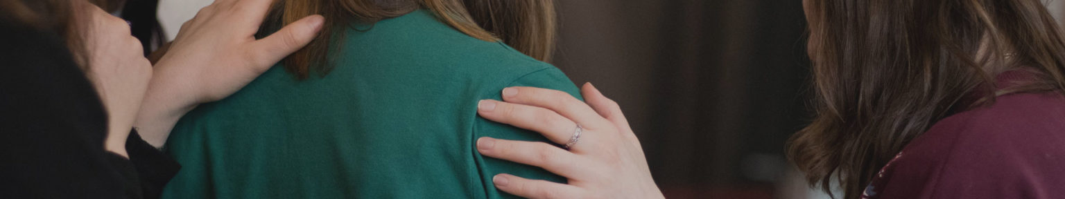 Hands gently resting on a person's shoulders in support