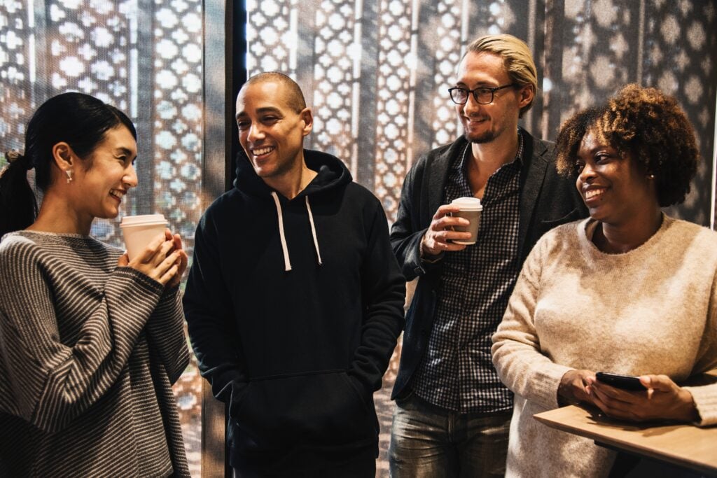 Diverse group of church members chatting and drinking coffee together